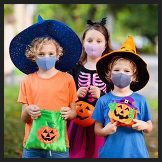 3 children trick-or-treating wearing costumes, protective masks