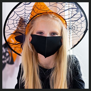 Girl with witch costume, protective mask