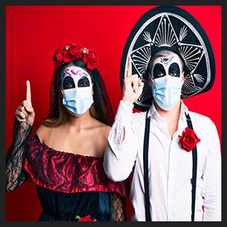 Day of the Dead couple with painted faces wearing costumes, protective masks 