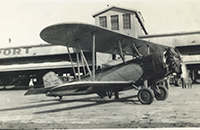 US Mail Biplane on Tarmac in Front of Fort Worth Airport, Meacham Field Hangar, photograph, undated