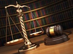 scales and gavel on desk with colorful books in the background
