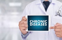 man in labcoat holding tablet saying Chronic Diseases